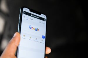 Hand holding a smartphone showing Google search